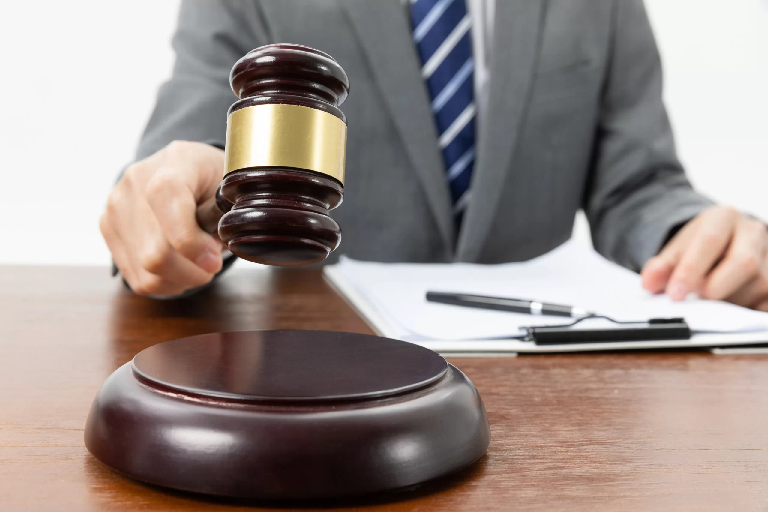 closeup-shot-of-person-with-gavel-in-hand-and-papers-on-the-table